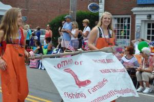 Fishermen's daughters Brook Linnell and Jamie Rushnak proudly walk the WOFF banner in Chatham's 4th of July parade, 2014.